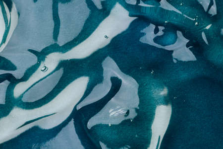 Transparent hyaluronic acid gel on a blue background.の写真素材