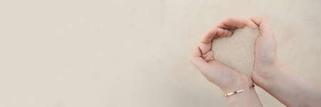 Womens hands hold white beach sand.の写真素材