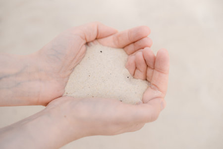 Womens hands hold white beach sand.の写真素材