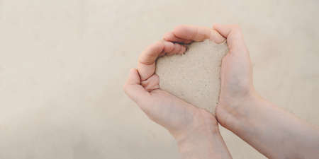 Womens hands hold white beach sand.の写真素材