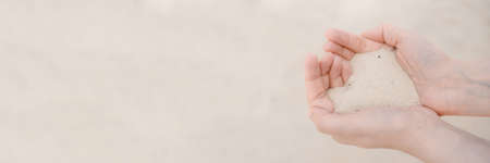 Womens hands hold white beach sand.の写真素材