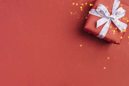 Gift boxe with white bow on a red backdrop.の写真素材