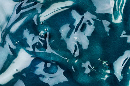 Transparent hyaluronic acid gel on a blue background.の写真素材