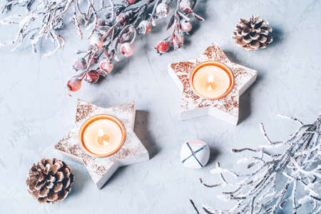 A composition of candlesticks, snow branches and Christmas decorations.の写真素材