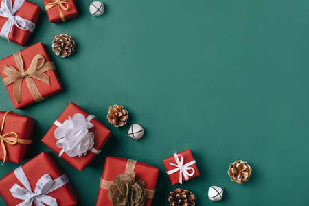 Gift boxes with white and brown bows on a green backdrop.の写真素材