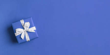 Gift boxe with white bow on a blue backdrop.の写真素材