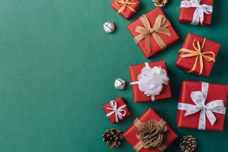 Gift boxes with white and brown bows on a green backdrop.の写真素材