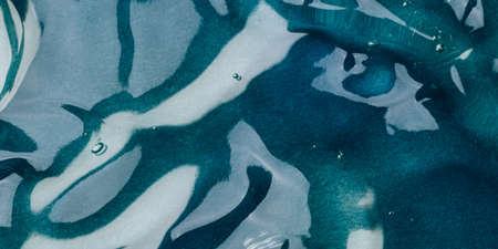 Transparent hyaluronic acid gel on a blue background.の写真素材