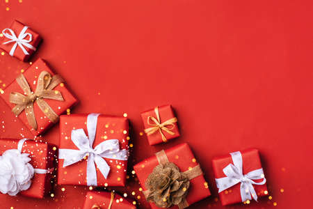 Gift boxes with white and brown bows on a red backdrop.の写真素材