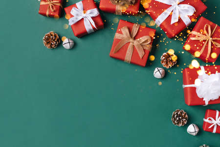Gift boxes with white and brown bows on a green backdrop.の写真素材