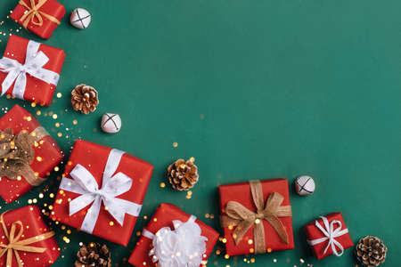 Gift boxes with white and brown bows on a green backdrop.の写真素材