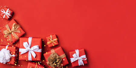 Gift boxes with white and brown bows on a red backdrop.の写真素材