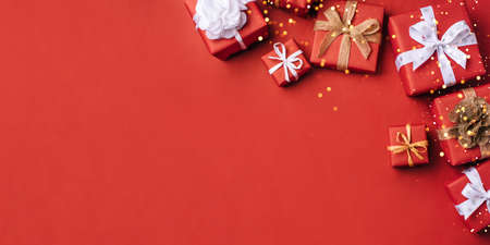 Gift boxes with white and brown bows on a red backdrop.の写真素材