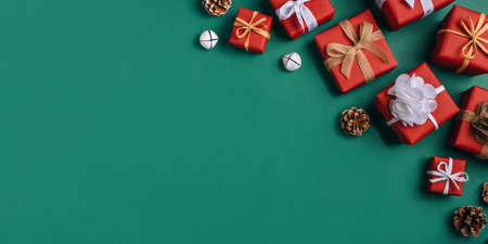 Gift boxes with white and brown bows on a green backdrop.の写真素材