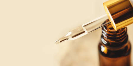 Pipette with cosmetics on a beige backgroundの写真素材