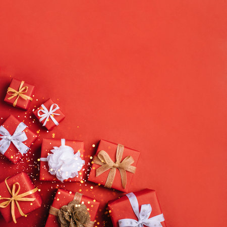 Gift boxes with white and brown bows on a red backdrop.の写真素材
