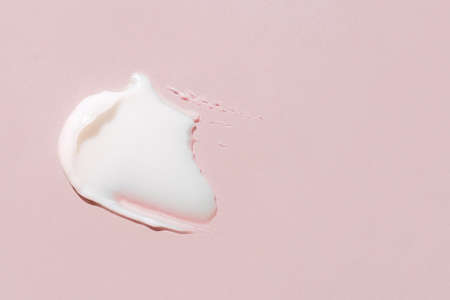 Smear of cosmetic cream on a pink background.の写真素材