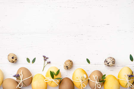 Easter eggs with flowers on a white table.の写真素材