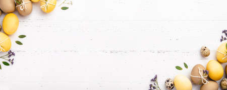 Easter eggs with flowers on a white table.