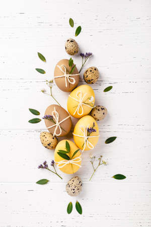 Easter eggs with flowers on a white table.の写真素材