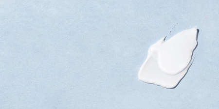 Smear of cream on a blue background.の写真素材