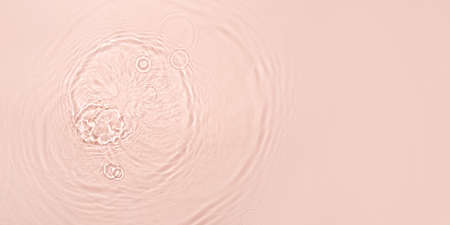 The texture of water on a pink background.
