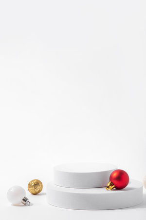 Cosmetic background for Christmas and winter holiday. White podium and christmas balls on white background.の写真素材