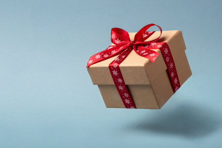 Flying Christmas gift box with red bow.の写真素材