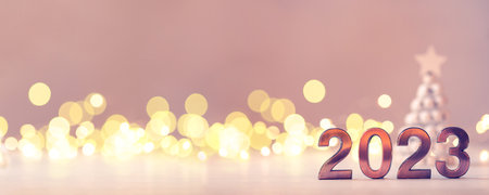 Metal numbers 2023 on table with bokeh lights.