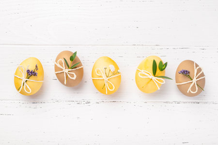 Easter eggs with flowers on a white table.の写真素材