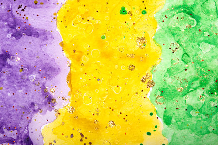 Watercolor background for Mardi Gras party. Fat Tuesday Holiday. Celebration greeting card. Purple, yellow and green colors with gold sequins.の写真素材