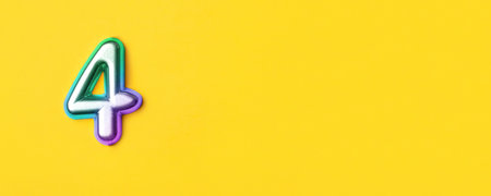 4 years celebration. Banner with birthday greetings. Multi colored metal number four on a yellow background. Copy space, top view.の写真素材