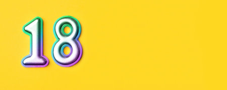 18 years celebration. Banner with birthday greetings. Multi colored metal number eighteen on a yellow background. Copy space, top view.の写真素材