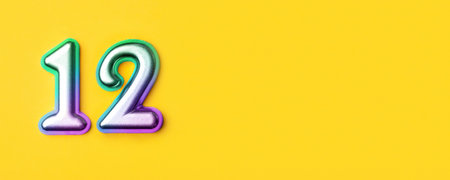 12 years celebration. Banner with birthday greetings. Multi colored metal number twelve on a yellow background. Copy space, top view.の写真素材