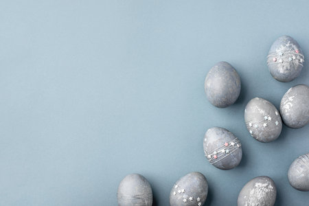Gray-blue Easter eggs with stars on a blue table.の写真素材