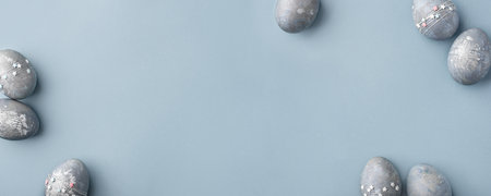 Gray-blue Easter eggs with stars on a blue table.の写真素材
