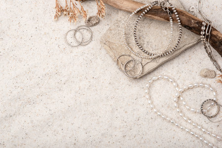 Beautiful Silver and Pearl Jewelry on white sand.の写真素材