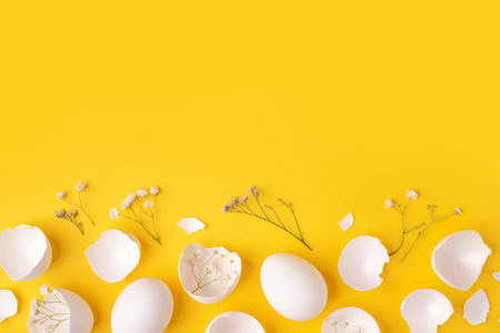 White Easter eggs and shells on a bright yellow background.の写真素材