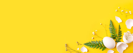White Easter eggs and shells on a bright yellow background.の写真素材