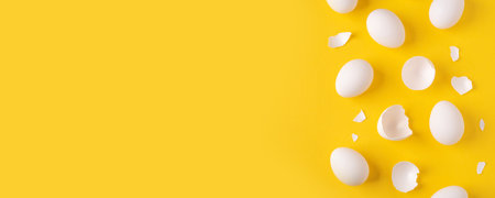 White Easter eggs and shells on a bright yellow background.の写真素材