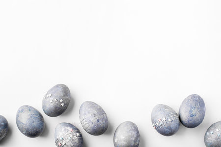 Gray-blue Easter eggs with stars on a white table.の写真素材
