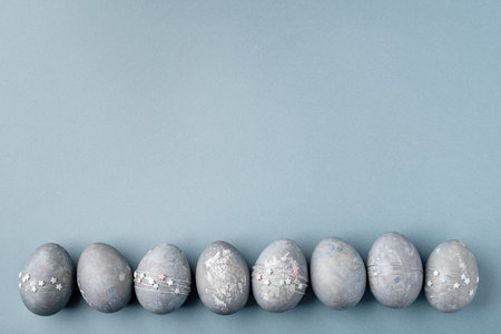 Gray-blue Easter eggs with stars on a blue table.の写真素材