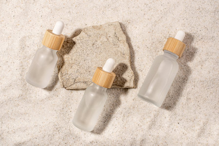 Glass bottles with a cosmetic product on a natural sandy background. top view.の写真素材
