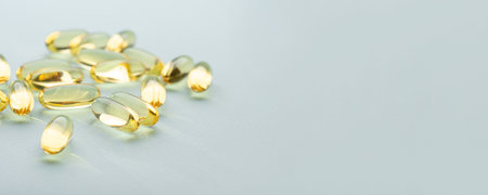 Omega 3 fish liver oil capsules on blue background. Close up, front view.の写真素材