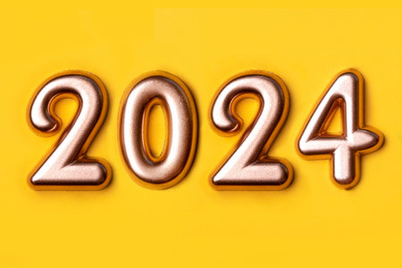 Metallic gold numbers 2024 on a yellow background. Happy New Year 2024.