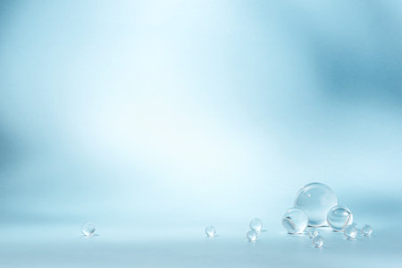 Blue background with transparent glass balls. Minimal concept and soft sunlight.の写真素材