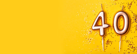 40 years celebration. Greeting banner. Gold candles in the form of number forty on yellow background with confetti.の写真素材