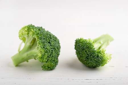 Fresh green broccoli on a white wooden background.