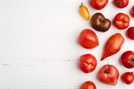 Fresh harvest of red tomatoes on a white wooden table. Top view.の写真素材