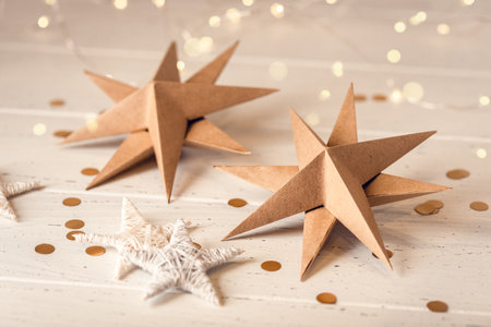 Paper Christmas stars on white wooden table. Front view.の写真素材